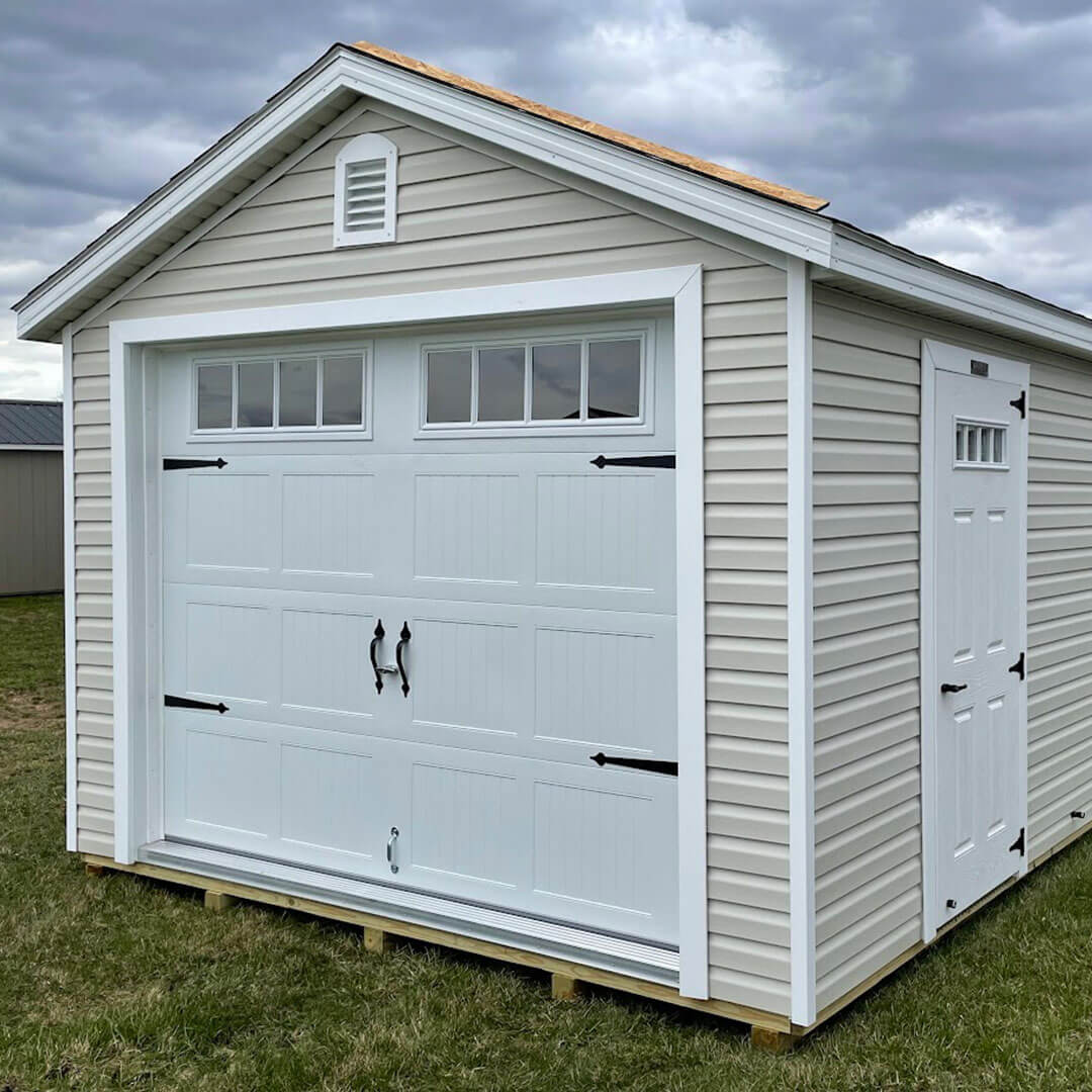 Tan gable garage with white trim and doors