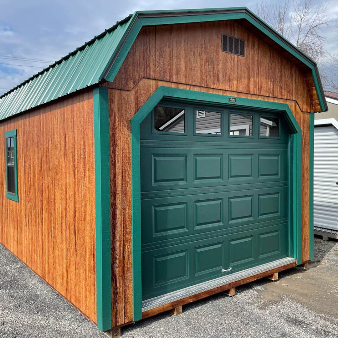 Wooden gambrel garage with green trim and doors