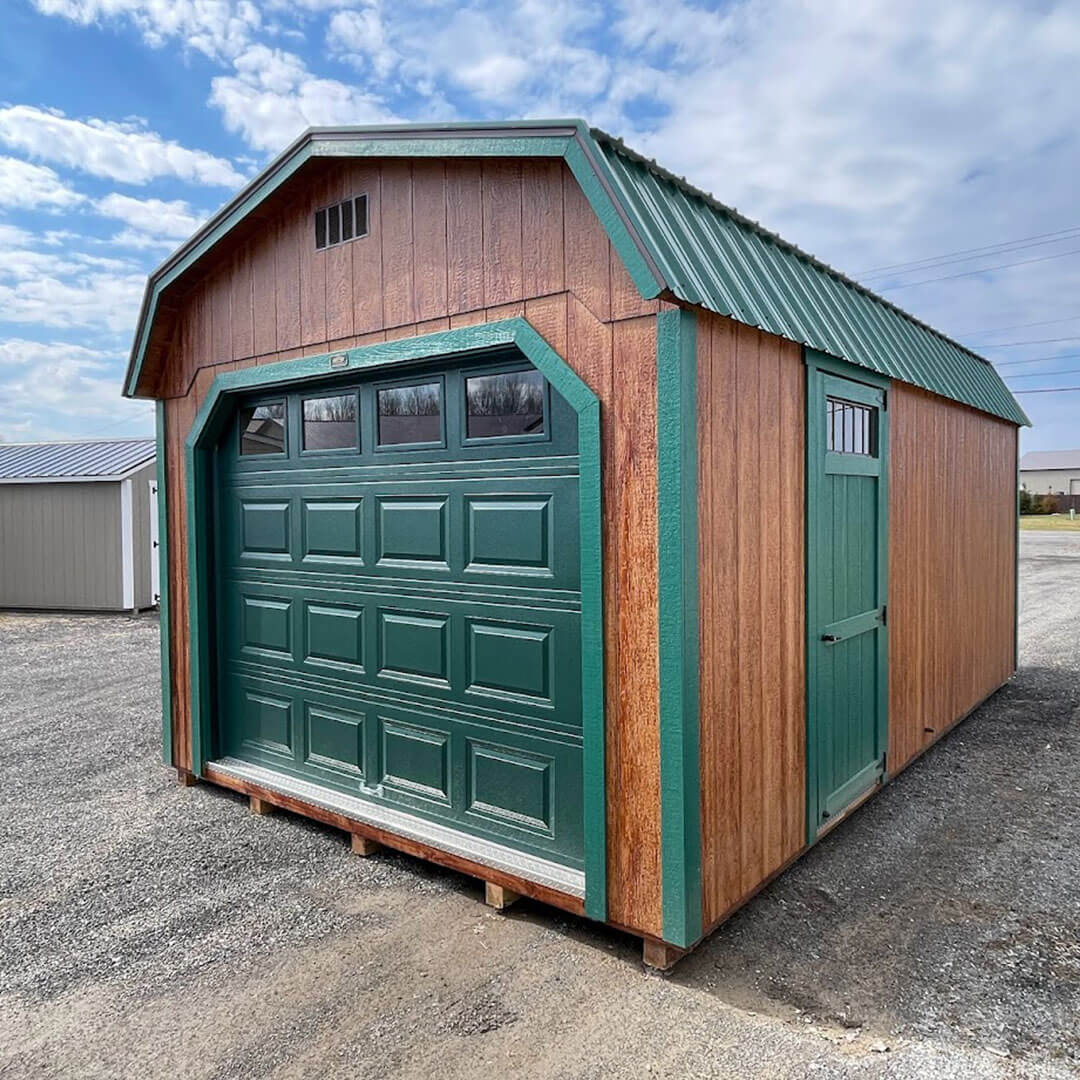 Wooden gambrel garage with green doors and trim